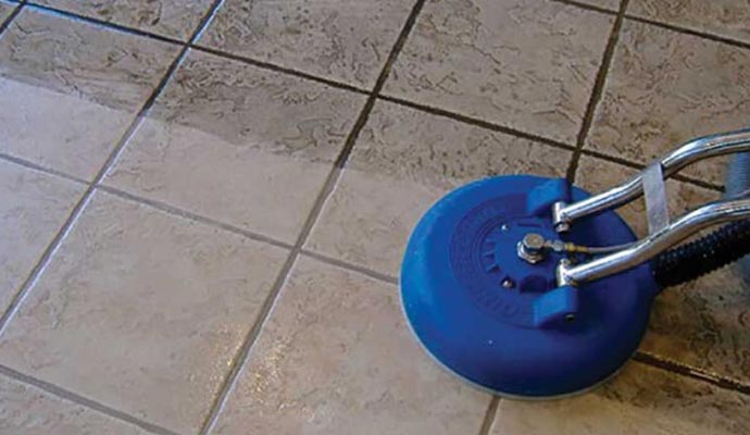 Cleaning floor tiles by a worker